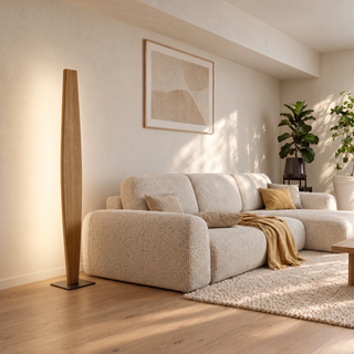 Stehleuchte Stella aus Eichenholz in Spindelform im hellen Wohnzimmer neben dem Sofa, indirektes Licht an der Wand