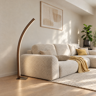 Stehleuchte Solara Meridian aus Walnuss mit feiner Ahornlinie: geschwungene Bogenleuchte mit LED-Lichtlinie neben einem Sofa im Wohnzimmer