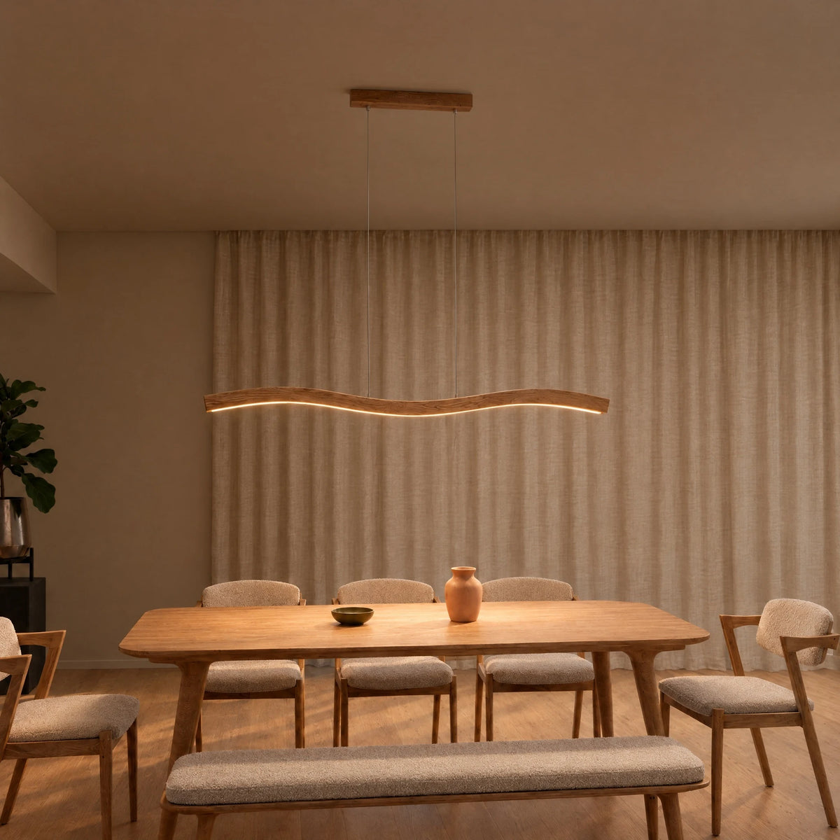 SpeicherArt Mila pendant light: double-curved solid oak light, switched on above a wooden dining table in front of a light linen curtain