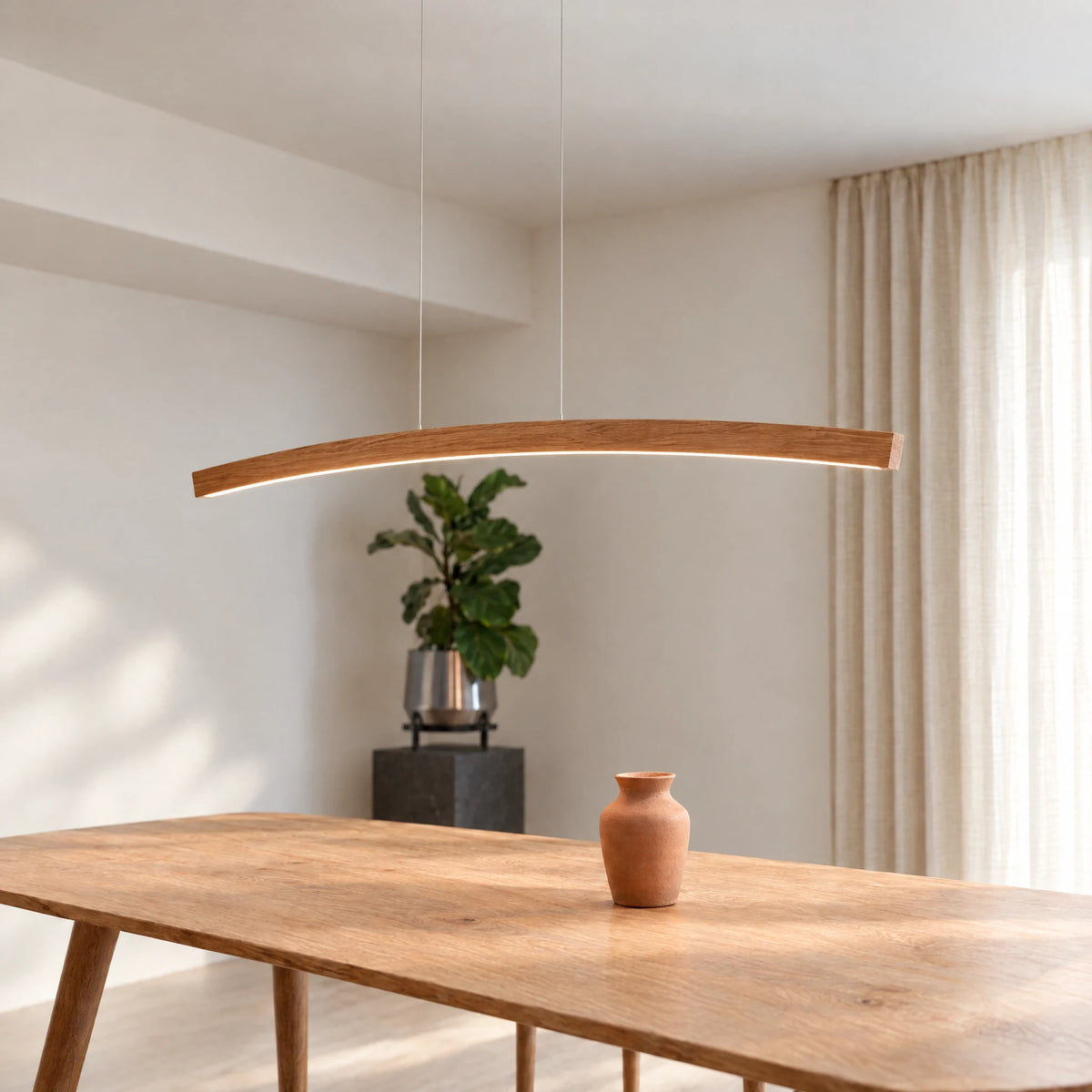Novara pendant light by SpeicherArt: curved arc in solid oak with a light line on the underside, above a dining table