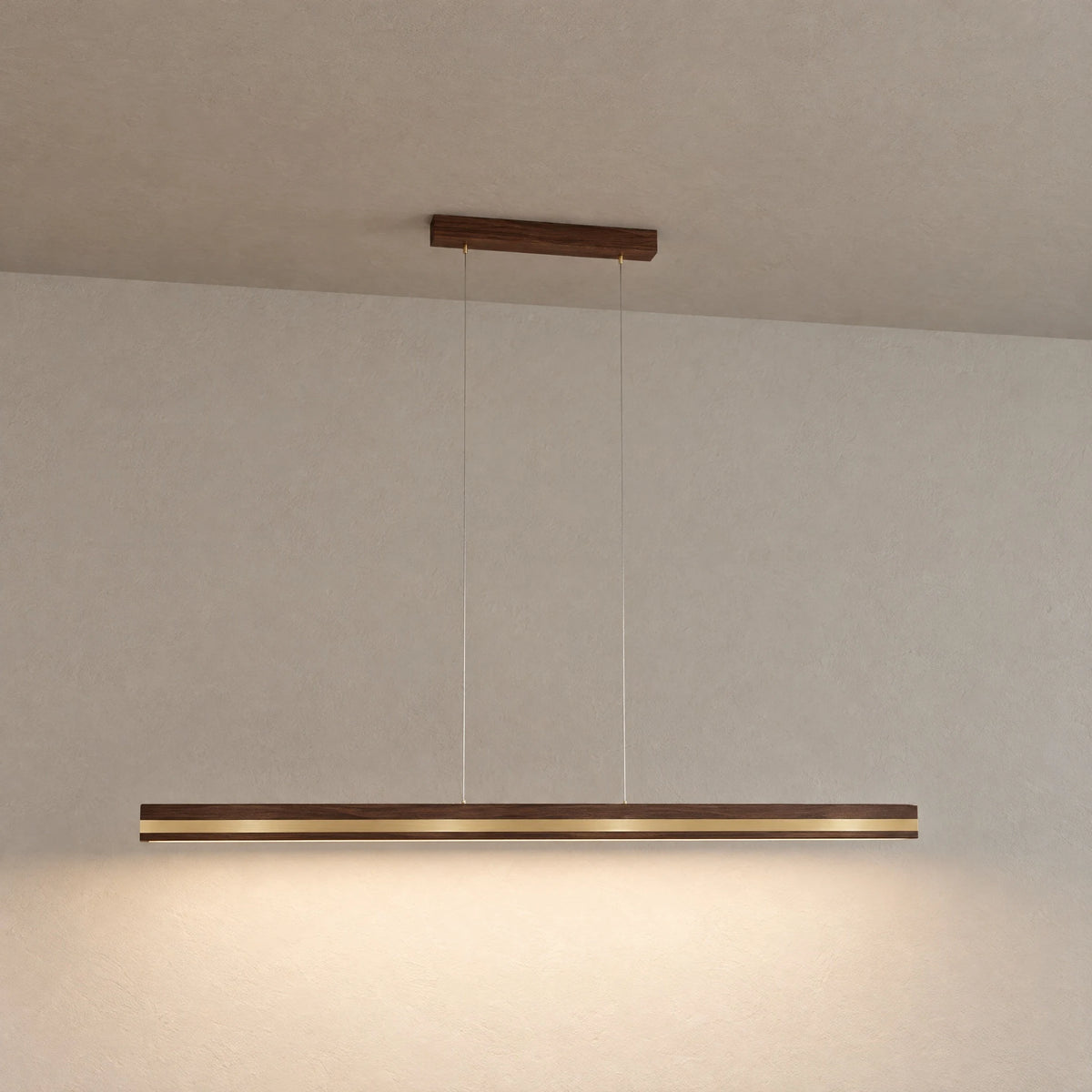 Veta pendant light in walnut with brass inlay, hanging freely against a light plaster wall